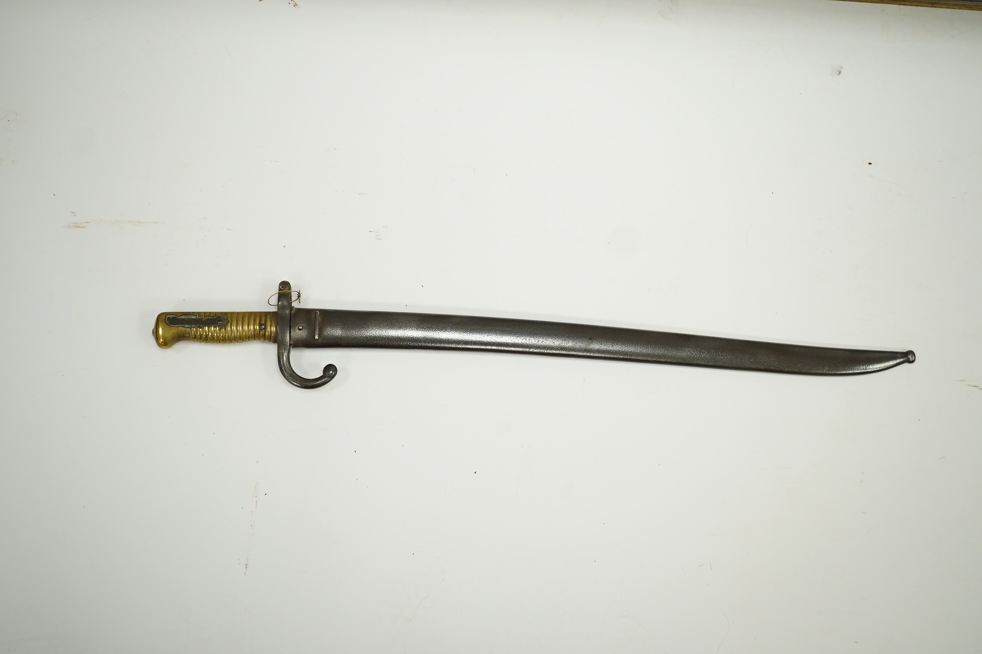 A French bayonet for a chassepot rifle, regulation blade dated 1871 and regulation hilt, in its iron scabbard. Condition - fair